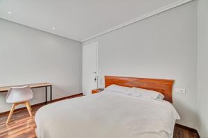 a bedroom with a bed and a desk and a chair at Apartamento El Rincón Logroñes by Clabao in Logroño