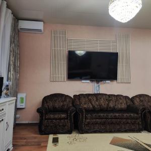 a living room with a couch and a flat screen tv at Резидент in Dnipro