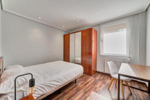 a bedroom with a bed and a desk and a window at Apartamento El Rincón Logroñes by Clabao in Logroño