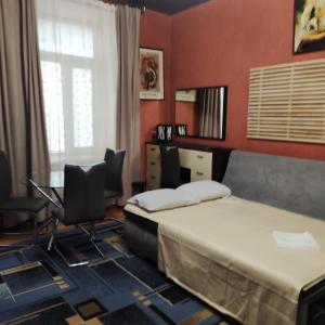 a bedroom with two beds and a desk and chairs at Резидент in Dnipro