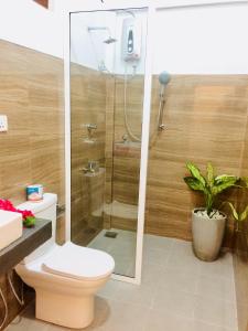 Tropicana Home Stay في آروغام باي: حمام مع دش مع مرحاض ومصنع