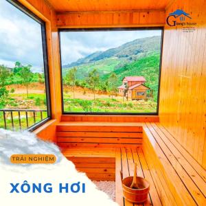 a large window in a wooden room with a view at Giăng's House Farmstay & Glamping in Bao Loc