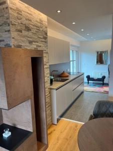 a kitchen with white cabinets and a stone wall at Appartement Inntalblick in Pill