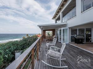 een huis met stoelen op een terras naast de oceaan bij do not use this profile in Sheffield Beach