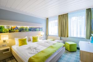 um quarto de hotel com uma cama grande com almofadas amarelas em Ferien Hotel Spree-Neisse em Neuhausen