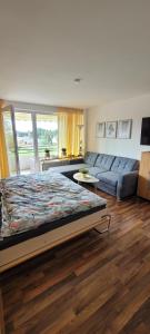 una camera con un grande letto e un divano di Anna Altreichenau a Neureichenau