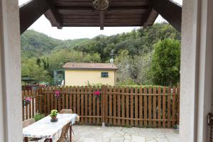 une terrasse couverte avec une clôture en bois, une table et une clôture dans l'établissement Ca' da Lalla by Wonderful Italy, à Varazze