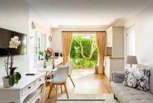 a kitchen and living room with a couch and a table at Guest suite - Leafy Constantia Guest House in Cape Town