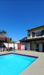 a swimming pool in front of a house at Sunset Hostel Guarujá in Guarujá