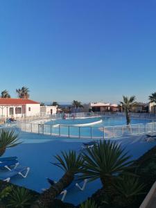 uitzicht op een zwembad met palmbomen bij Casa Naturaleza 2 in Caleta De Fuste