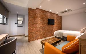 a hotel room with a bed and a brick wall at Hotel East Taichung in Taichung