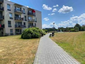 a walkway in front of a building in a field at City Park Apartment in Vilnius