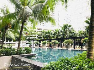 una piscina en medio de un edificio con palmeras en Palazio Mount Austin 2-3pax 5mins Toppen , Ikea ,AEON,Water Theme park, en Johor Bahru