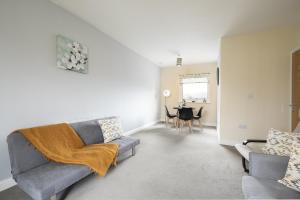 a living room with a couch and a table at Inaras place in Aylesbury