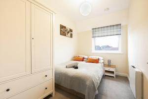 a bedroom with a bed and a dresser and a window at Inaras place in Aylesbury