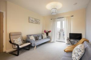 a living room with a couch and a tv at Inaras place in Aylesbury