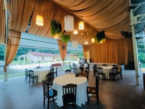 uma sala de jantar com mesas e cadeiras e um dossel em LiLLA Rainforest Retreats by Swing & Pillows em Hulu Langat