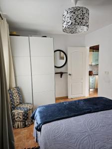 - une chambre avec un lit, une chaise et un miroir dans l'établissement Casa Luz, à Agaete