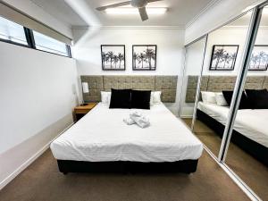 Un dormitorio con dos camas y dos espejos. en WhitsunStays - The Regal (2br/2bth, Central), en Mackay