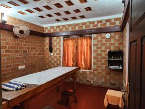 a room with a table and a brick wall at Treebo Trend God'S Own Country Ayurveda Resorts in Kovalam