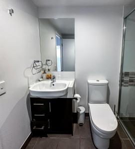 a bathroom with a sink and a toilet at WhitsunStays - The Regal (2br/2bth, Central) in Mackay