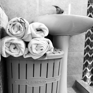 uma pilha de toalhas num caixote do lixo ao lado de um lavatório em gaydi em Gori