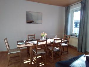 uma sala de jantar com uma mesa de madeira e cadeiras em Weingut-Ferienwohnung Heinz Dostert em Nittel