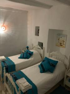 two beds in a room with blue towels on them at Dar Lola in Houmt Souk