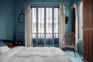 a bedroom with a bed and a window and a chair at MAISON MOUZ in Paris