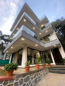 a house with potted plants in front of it at West Valley Villa , Casa Raywood in Lonavala