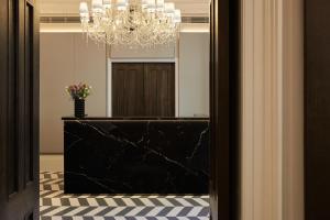 a hallway with a mirror and a chandelier at Eccleston Square Hotel in London