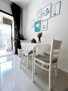 einen weißen Esstisch mit Stühlen und einem weißen Tisch in der Unterkunft Vin Grand Park - TP. Thủ Đức in Tân Vạn