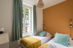 ein Schlafzimmer mit zwei Betten und einem Fenster in der Unterkunft Le Cargo - A 300m de la plage de Rochebonne in Saint-Malo