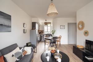ein Wohnzimmer mit Sofa und Tisch in der Unterkunft Le Cargo - A 300m de la plage de Rochebonne in Saint-Malo