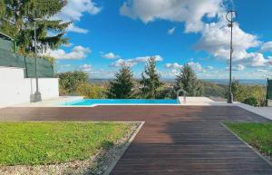 a swimming pool with a wooden walkway next to a house at ZAGREB HOUSE MEDVEŠČINA/WITH POOL in Zagreb