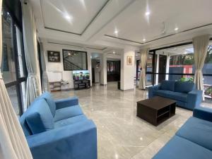 a living room with blue chairs and a table at West Valley Villa , Casa Raywood in Lonavala
