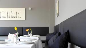 un comedor con mesas blancas y sillas azules en Apartment Hotel Lindeneck, en Erfurt