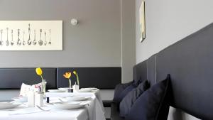 a dining room with white tables and blue chairs at Apartment Hotel Lindeneck in Erfurt