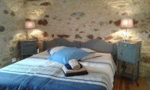 a bedroom with a bed with two night stands and two lamps at Gîte des Champs Lalaurie in Sauveterre-la-Lémance +34 photos