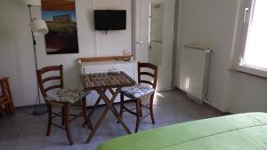 Zimmer mit einem Tisch, 2 Stühlen und einem TV in der Unterkunft Casa vacanze Il cancello rosso in Montefranco