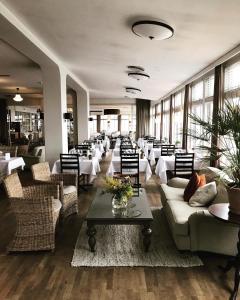 ein Esszimmer mit Tischen, Sofas und Stühlen in der Unterkunft Grand Hôtel Mölle in Mölle