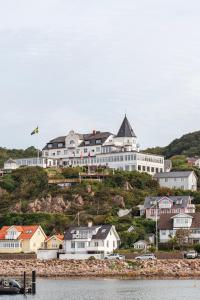a large building on top of a hill with houses at Grand Hôtel Mölle in Mölle