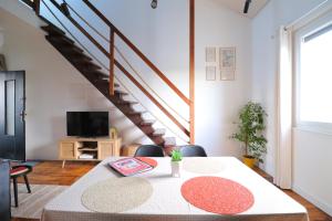 a living room with a table and a staircase at Le Boho - Charmant T3 - gare à 5 min à pieds in Bergerac