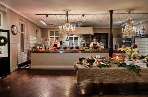 two people in a kitchen with a counter with food at Grand Hôtel Mölle in Mölle