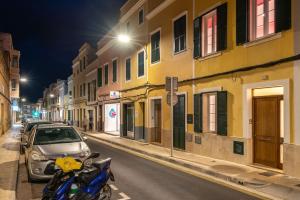 a motorcycle parked on the side of a street at night at Ca Na Bel 4 bedroom house, Ciutadella in Ciutadella