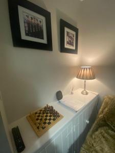 einen Tisch mit einer Lampe und einem Schachbrett darauf in der Unterkunft Máire Toiréasa – cosy refurbished property in the Gaeltacht Quarter in Belfast