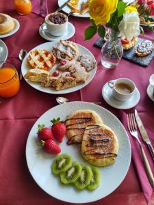 une table avec des assiettes de produits pour le petit-déjeuner et des fraises dans l'établissement Podere Il Belvedere su Cortona, à Castiglion Fiorentino