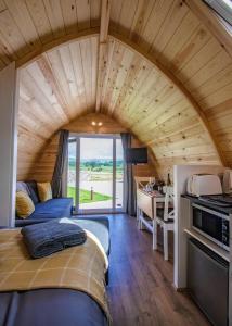 a bedroom in a tiny house with a large wooden ceiling at Malhamdale Glamping in Skipton