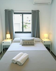 2 camas en una habitación con 2 lámparas y toallas en Hostal Costa, en Ibiza