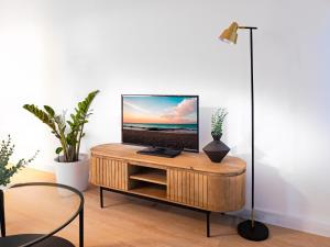 a living room with a tv on a wooden table at Canaima Sea View/Terrace/Pool in Mogán